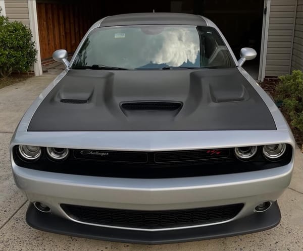 Silver Dodge Challenger with a matte black hood