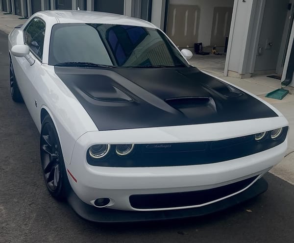 White Dodge Challenger with a matte black hood wrap
